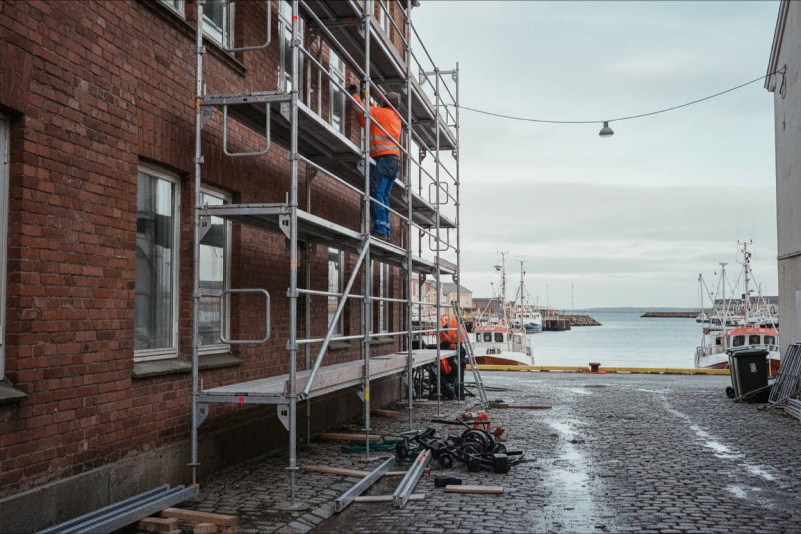Scaffolders building a scaffold on a building facade in a Norwegian coastal town